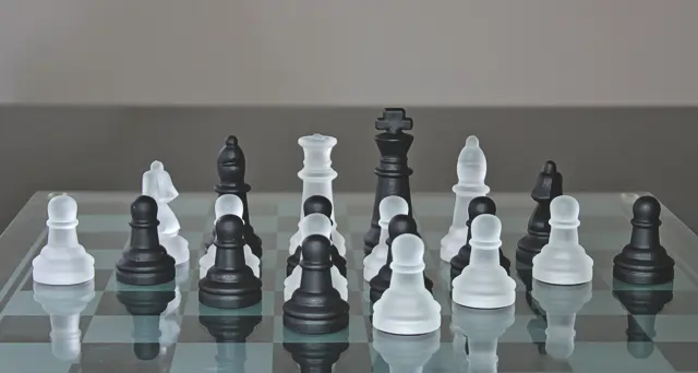 Image of black and white crystal chess pieces on a glass chess board